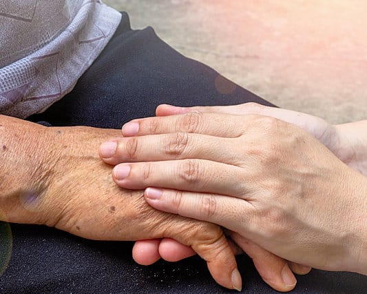 Älterwerden mit Lust und Würde - 6 fröhliche, lachende ältere Menschen im Porträt - Hand einer älteren Person liegt in den Händen einer jüngeren Person